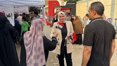 رئيسة حي شبرا الخيمة توزع الأعلام على المواطنين أمام لجان الانتخابات (صور) 