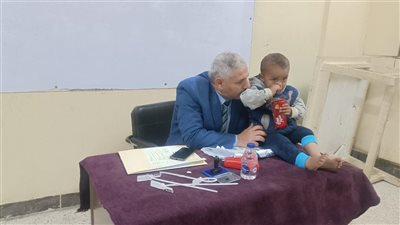 رئيس لجنة مدرسة اللواء أحمد عبد التواب بالفيوم يحمل طفلا ليدلي والده بصوته