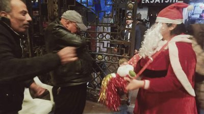 بملابس بابا نويل.. فتاة توزع الحلوى بالكنيسة المرقسية فى الإسكندرية