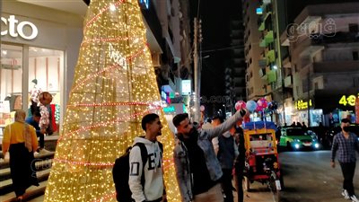 تحدوا الطقس السيئ.. المنايفة يلتقطون الصور التذكارية بجوار أكبر شجرة كريسماس| صور