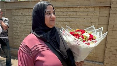 أم تنتظر ابنتها بالورود خارج لجان الثانوية العامة: 