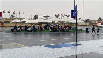 هربا من الأمطار.. زوار معرض الكتاب يحتمون بالمظلات | صور 