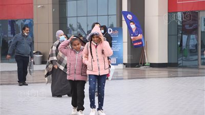 فرح لا حدود له.. بهجة الأطفال بتساقط الأمطار على معرض الكتاب |صور