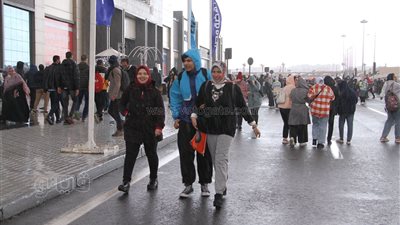 25 صورة ترصد سقوط أمطار كثيفة على زوار معرض الكتاب