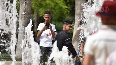 الأطفال يهربون من حرارة الشمس بالاستحمام في نافورة مياه حديقة الأزهر | فيديو وصور