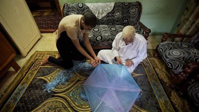 في مواجهة أيام الحظر.. أب يشارك أولاده صناعة الطائرات الورقية| صور