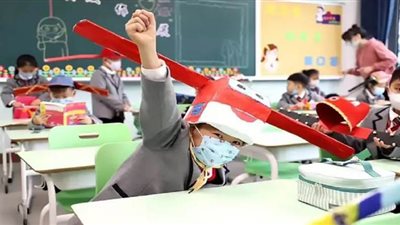 الصين تستخدم قبعات خاصة لحماية أطفال المدارس من كورونا | فيديو وصور