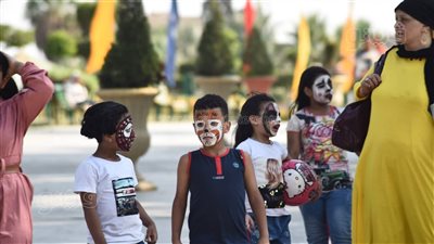 رسم الأقنعة على الوجوه يجذب الأطفال في الحديقة الدولية احتفالا بالعيد |صور 