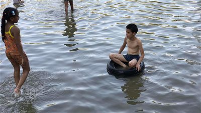 هربا من الحر.. استحمام الأطفال في بحيرة الحديقة اليابانية| فيديو وصور 