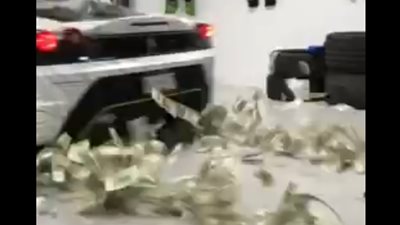 شاب يثير الغضب بنثر أمواله أسفل سيارة (فيديو)