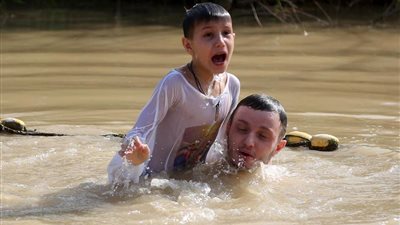 مسيحيون يحتفلون بالغطاس في مياه نهر الأردن (صور)